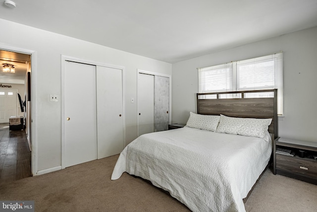 carpeted bedroom featuring multiple closets