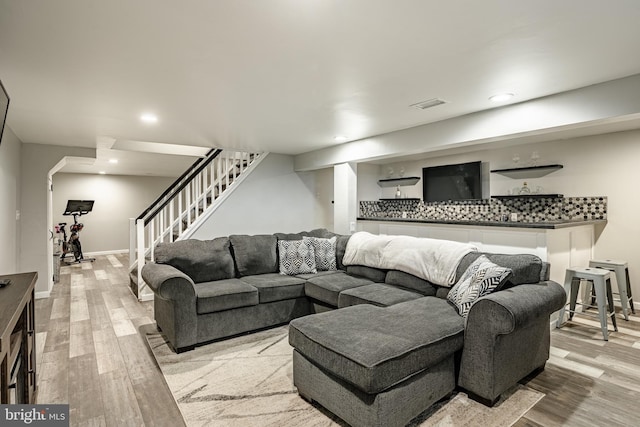 living area with visible vents, baseboards, light wood-style flooring, stairs, and recessed lighting