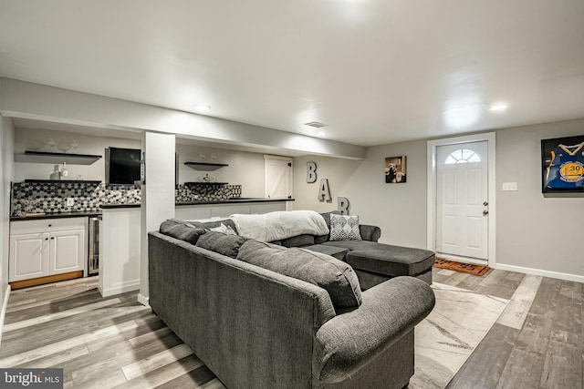 living area featuring light wood-type flooring, baseboards, and visible vents