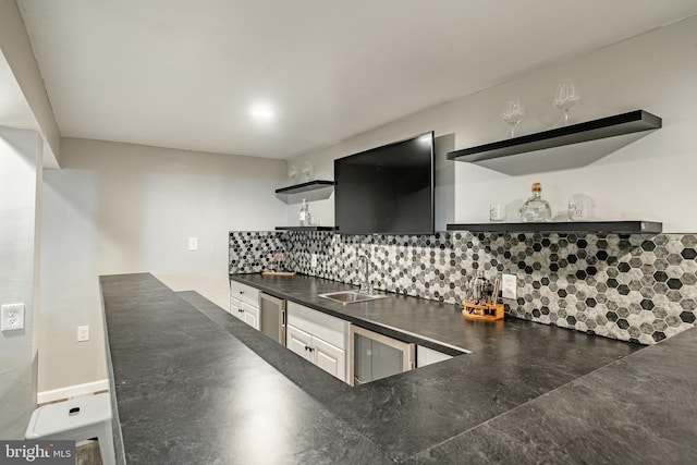 kitchen featuring a sink, white cabinets, backsplash, open shelves, and dark countertops