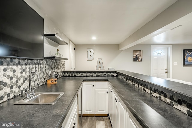 kitchen featuring dark countertops, white cabinetry, open shelves, and a sink