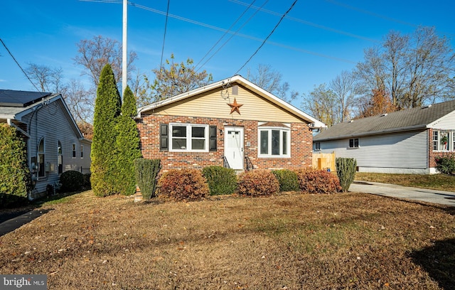 view of front facade with a front lawn and brick siding