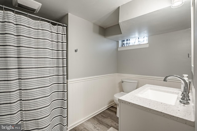 full bathroom featuring wainscoting, vanity, toilet, and wood finished floors