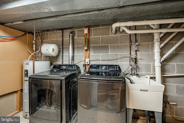 laundry room with laundry area, electric water heater, a sink, and washer and clothes dryer