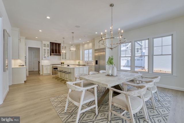 dining area with recessed lighting, a notable chandelier, light wood-style flooring, and baseboards