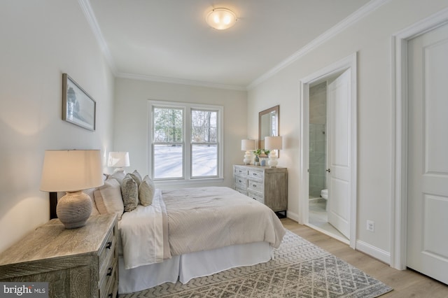 bedroom featuring ornamental molding, baseboards, light wood-style floors, and ensuite bathroom