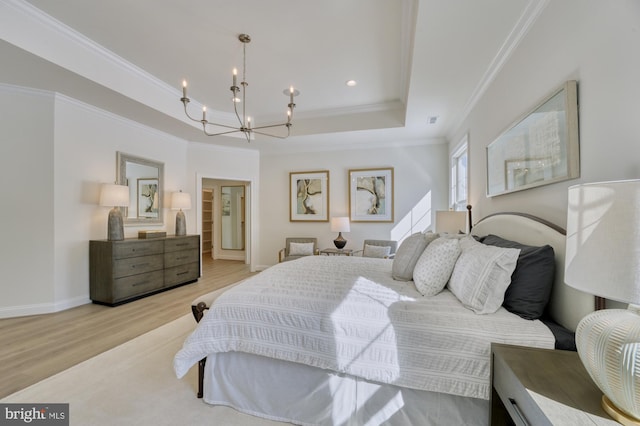 bedroom featuring baseboards, ornamental molding, wood finished floors, a raised ceiling, and an inviting chandelier