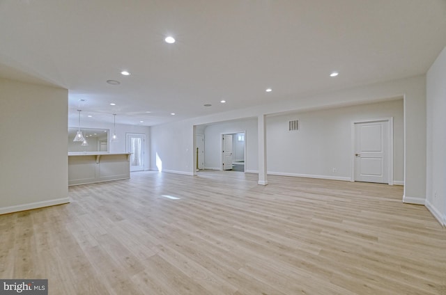 unfurnished living room with baseboards, light wood-type flooring, and recessed lighting