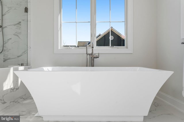 interior details featuring baseboards and a freestanding bath