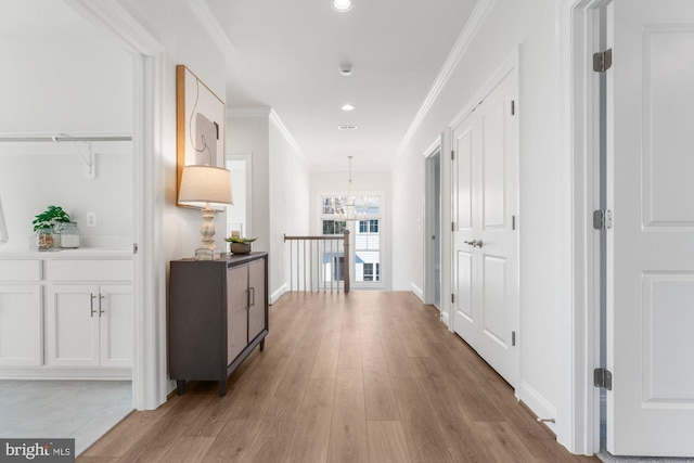 hallway featuring a notable chandelier, crown molding, light wood finished floors, and recessed lighting