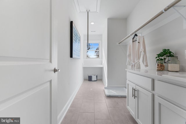 bathroom with baseboards, tile patterned flooring, and vanity