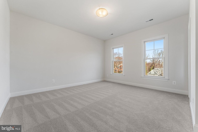 unfurnished room featuring baseboards, visible vents, and carpet flooring
