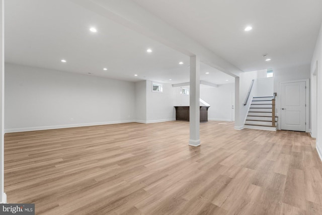 below grade area with stairway, recessed lighting, light wood-type flooring, plenty of natural light, and baseboards