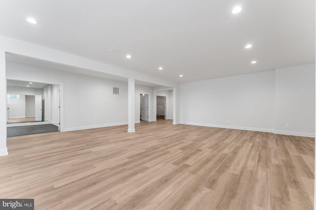below grade area with baseboards, visible vents, recessed lighting, and light wood-style floors