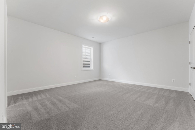 unfurnished room featuring baseboards and carpet