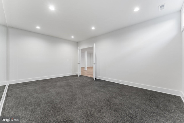 unfurnished room with dark carpet, recessed lighting, baseboards, and visible vents