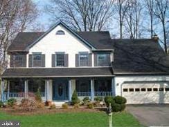 view of front of property featuring a porch, a garage, and a front yard