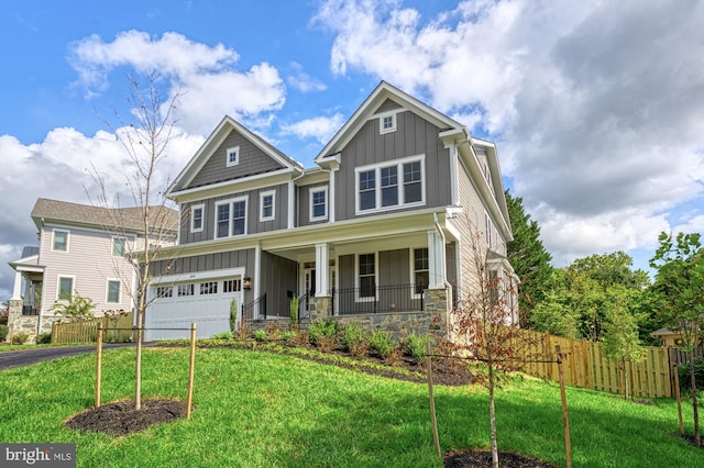 craftsman house featuring fence, aphalt driveway, board and batten siding, and a front yard