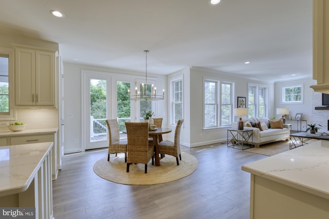 dining space with light wood-style floors, baseboards, an inviting chandelier, and recessed lighting