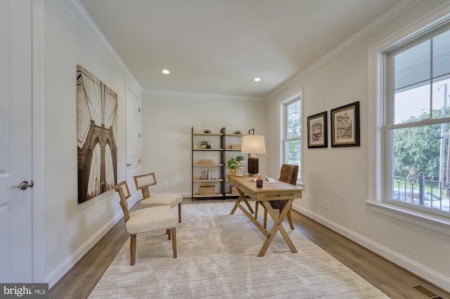 office with ornamental molding, light wood-style flooring, and a healthy amount of sunlight