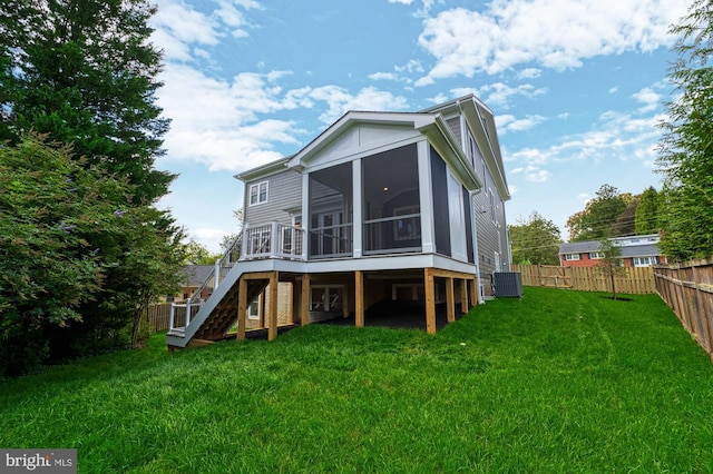 back of property with a lawn, stairway, a fenced backyard, and a sunroom