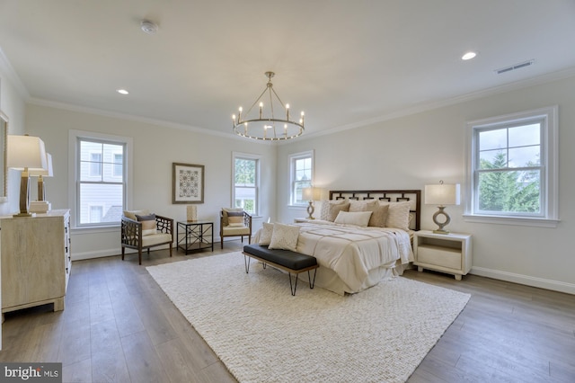 bedroom with baseboards, ornamental molding, and wood finished floors