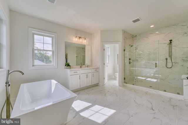 full bathroom featuring marble finish floor, visible vents, toilet, vanity, and a freestanding tub