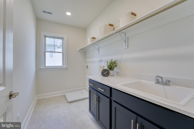 clothes washing area featuring cabinet space, light tile patterned floors, visible vents, hookup for a washing machine, and a sink