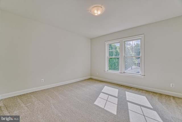 carpeted spare room with baseboards