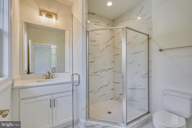 full bath with vanity, a marble finish shower, and toilet