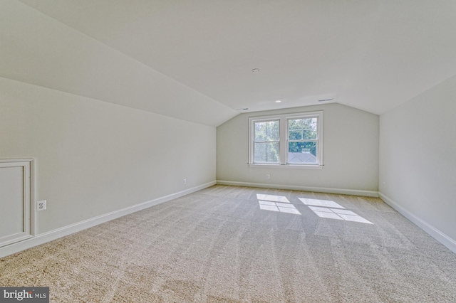 bonus room featuring light carpet, vaulted ceiling, and baseboards