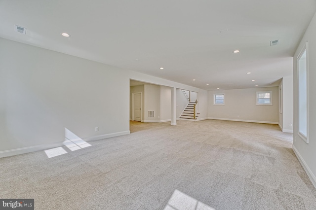 basement with stairway, recessed lighting, visible vents, and light colored carpet