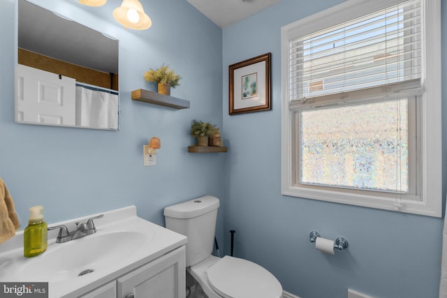 full bathroom featuring a healthy amount of sunlight, toilet, and vanity