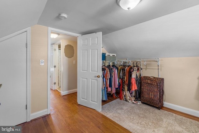 spacious closet featuring lofted ceiling and wood finished floors