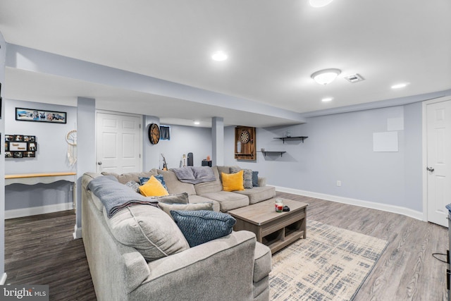 living room with recessed lighting, visible vents, baseboards, and wood finished floors