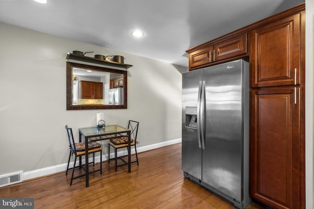 kitchen with stainless steel fridge, baseboards, visible vents, stainless steel fridge with ice dispenser, and wood finished floors