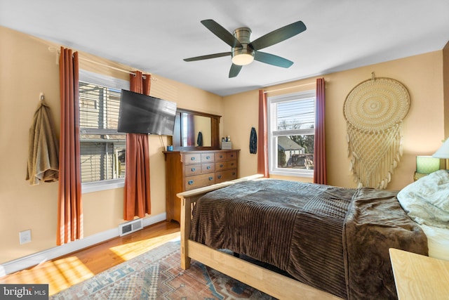 bedroom featuring visible vents, ceiling fan, and wood finished floors