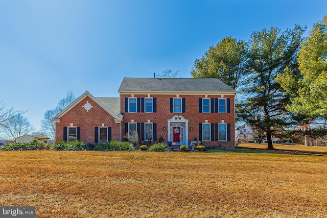 view of front facade featuring brick siding and a front yard