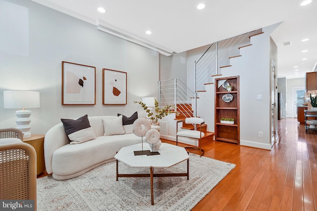 living room featuring visible vents, stairs, wood finished floors, and recessed lighting