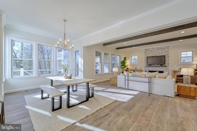 dining room featuring light wood-style flooring, ornamental molding, a chandelier, beamed ceiling, and baseboards