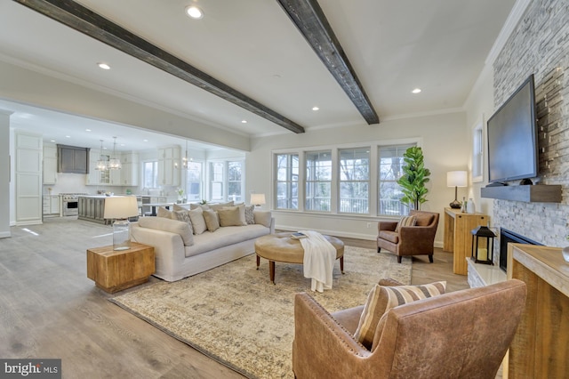 living room with a stone fireplace, baseboards, light wood finished floors, beamed ceiling, and crown molding