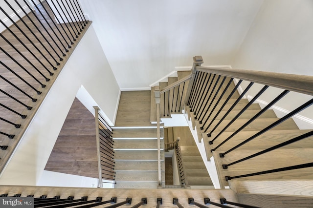 stairway featuring baseboards and wood finished floors