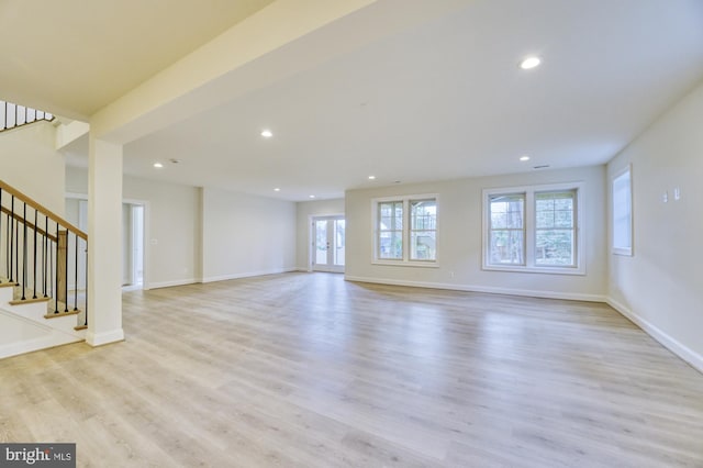 unfurnished living room with baseboards, stairway, light wood-type flooring, and recessed lighting