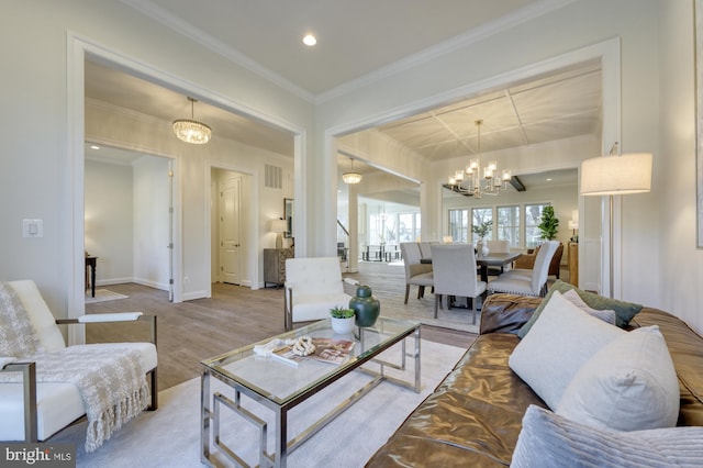 living room with crown molding, baseboards, wood finished floors, and a notable chandelier