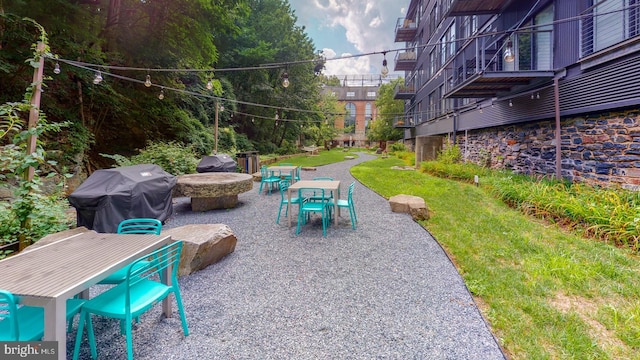 view of property's community with a yard, a fire pit, and a patio area