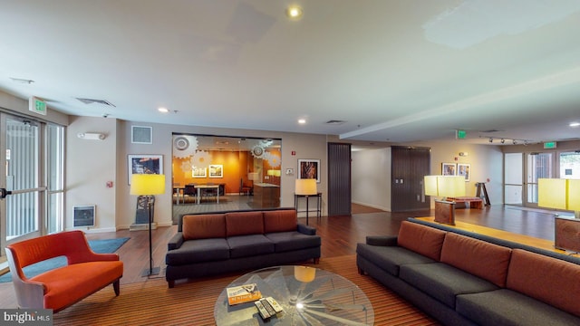 living room with heating unit and hardwood / wood-style flooring