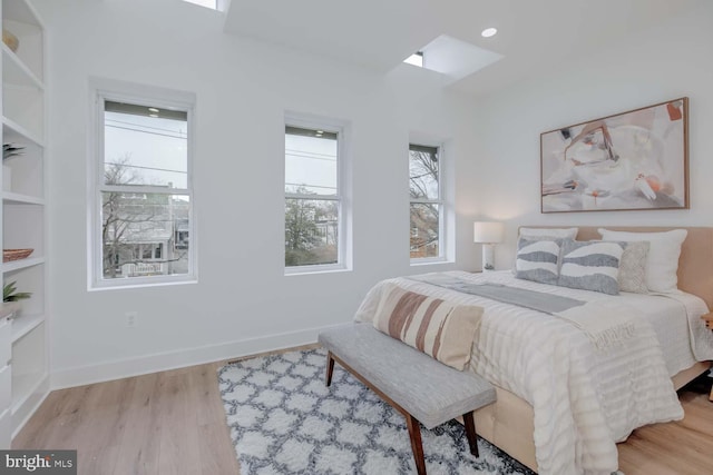 bedroom with baseboards and wood finished floors