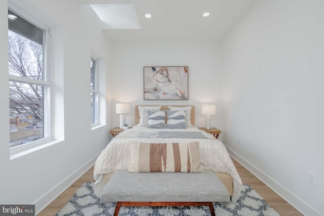 bedroom with light wood-type flooring, baseboards, and recessed lighting