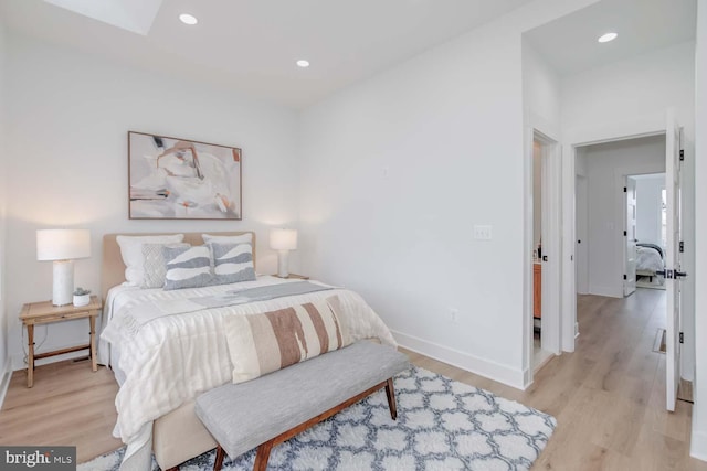 bedroom featuring light wood finished floors, baseboards, and recessed lighting