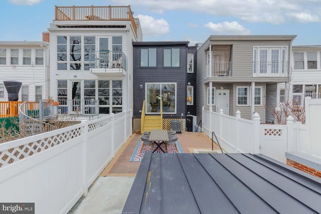 rear view of house with fence private yard and a balcony